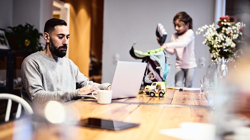 Ein Vater bei der Arbeit und mit seinem Kind