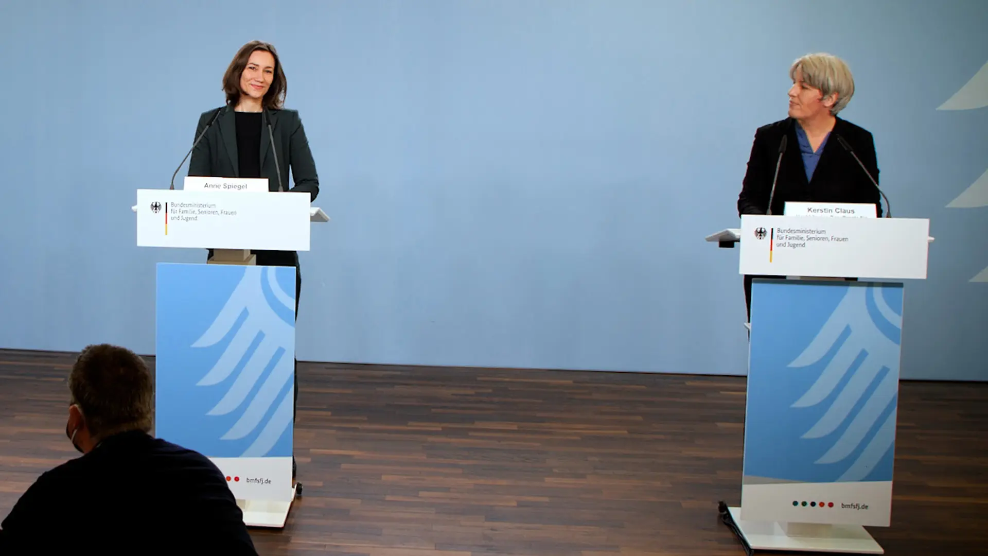 Anne Spiegel und die neue Missbrauchsbeauftragte Kerstin Claus im BMFSFJ vor einer blauen Wand
